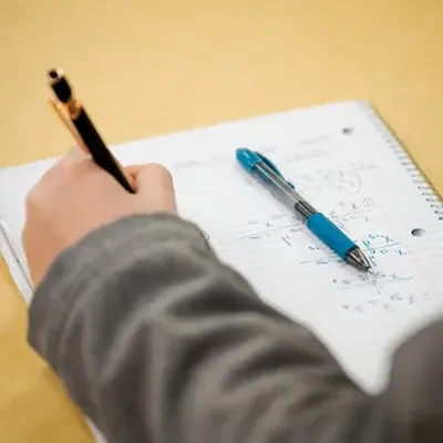 Close up of a student doing math in a notebook